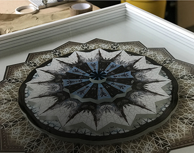 A circular mosaic framed art piece.